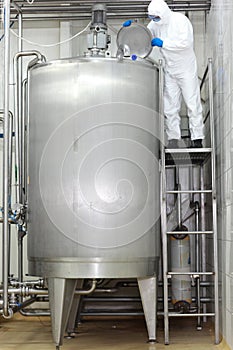 Technician controlling industrial process in tank