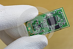A technician controls the quality of a mini wireless bluetooth wifi modules for mobile devices photo