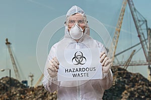 Technician in coverall in landfill warns against dangerous hazardous waste