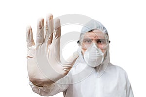 Technician in coveralls shows stop gesture. on white