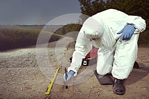 Technician Criminologist preparing tire print left in dust of field way for documentation