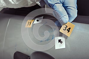 Technician criminologist working on developing of latent handprints on car door