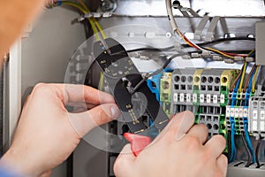 Technician cutting cable with fusebox in background photo