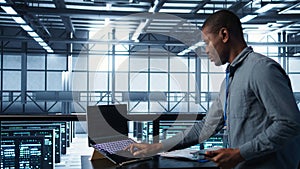 Technician in data center with laptop and tablet integrating AI technology