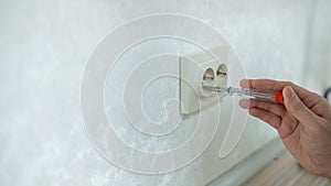 The technician determines the voltage in the socket.