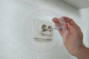 The technician determines the voltage in the socket.