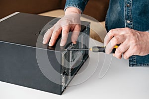 Technician disassemble computer with a screwdriver for problems diagnostic