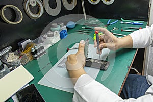 A technician disassembling a mobile phone in his small taller