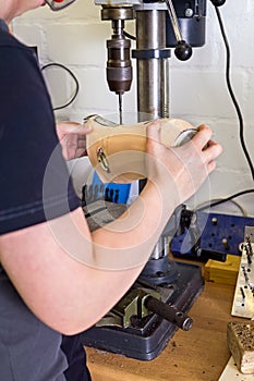 Technician drilling hole into prosthetic limb