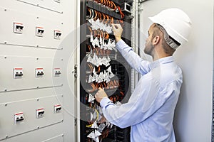 Technician engineer in datacenter. Network technician connecting fiber optic at server room.