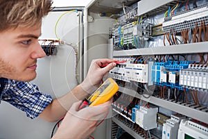 Technician examining fusebox with insulation resistance tester