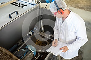 Technician examining processing machine