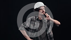 The technician explains by gesturing to the phone call and listens carefully to the person he is talking to. Isolated on