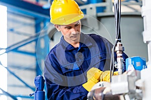 Technician in factory at machine maintenance