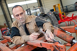 technician in factory at machine maintenance working with wrench