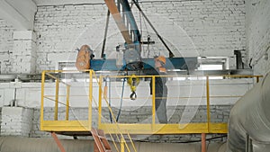 Technician, factory worker in uniform inspecting machinery on elevated platform