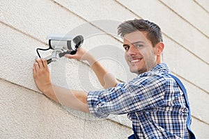Technician Fixing Cctv Camera On Wall