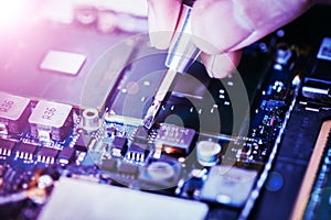 Technician is fixing a computer circuit board, hand and screwdriver