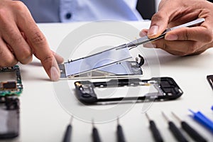 Technician Fixing Damaged Screen On Mobile Phone