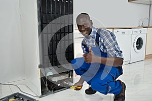 Technician Fixing Refrigerator