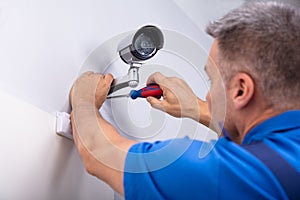 Technician Fixing Security Camera