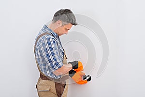 Technician fixing socket on wall