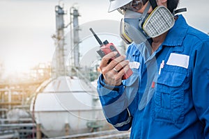 Technician with gas mask against petrochemical plant