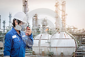 Technician with gas mask against petrochemical plant