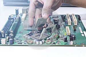 Technician hand holding the CPU for fixing and upgrade computer pc to repair inside The socket motherboard or equipment. Computer
