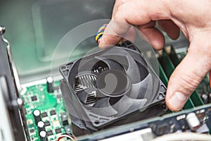 Technician hands installing CPU cooler fan on a computer pc motherboard