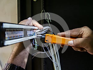 Technician hands installing network cables in server rack