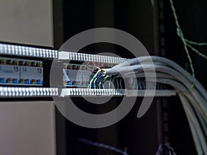 Technician hands installing network cables in server rack