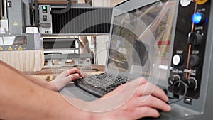 Technician hands operating the control panel of high precision CNC machine