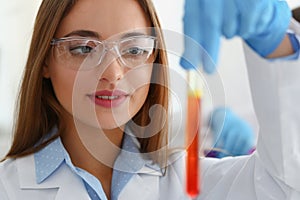 Technician hold in arms in protective gloves sample bottle