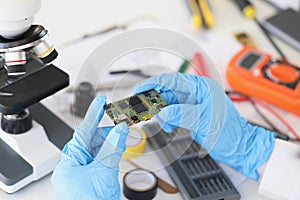 Technician hold component of digital device, repair smartphone at home