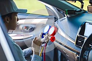 Technician holding monitor tool to check and fix car air conditioner system, Repairman checks car air conditioning system