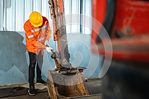 A technician holding a tool for maintenance or excavator at maintenance center, Heavy Duty Equipment Maintenance. Industrial