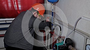 Technician inspecting heating system in boiler room