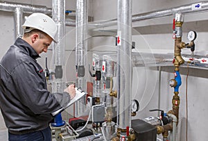 Technician inspecting heating system in boiler room