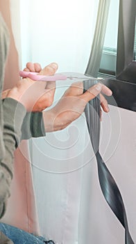 Technician inspects a window frame which is new installed a mosquito wire screen photo