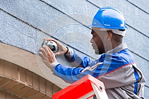 Technician Installing Camera On Wall