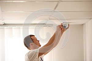 Technician installing CCTV camera on ceiling