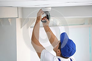 Technician installing CCTV camera on ceiling