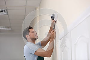 Technician installing CCTV camera on wall