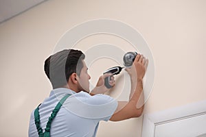 Technician installing CCTV camera on wall