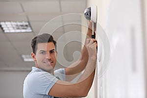 Technician installing CCTV camera on wall