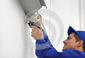 Technician installing CCTV camera on wall