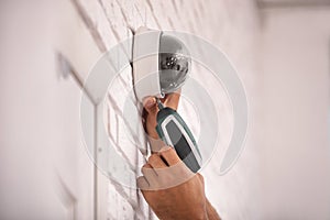 Technician installing CCTV camera on wall photo