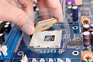 Technician installing CPU chip microprocessor to socket on motherboard