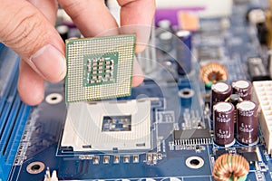 Technician installing CPU chip microprocessor to socket on motherboard